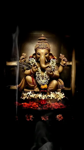 Ganesha Statue With Flower Garland And Red Petals