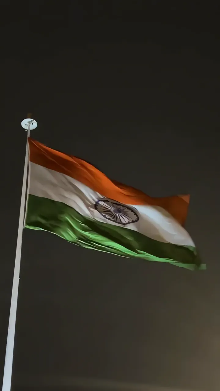 India Flag Flying At Night With Illuminated Ashoka Chakra