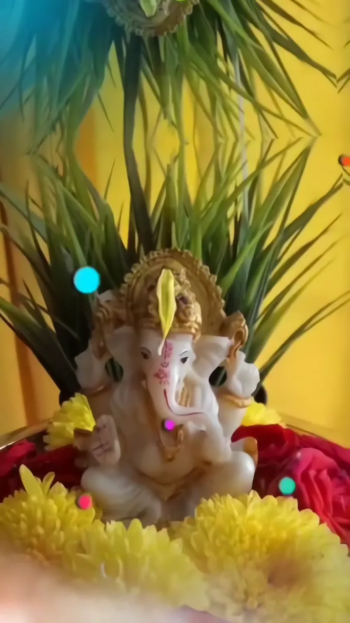 Ganesha Statue With Golden Crown And Yellow Flowers