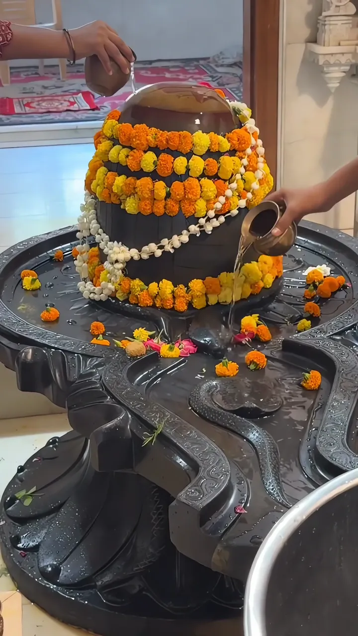 Shiva Lingam Ritual With Marigold Garland And Water Offering