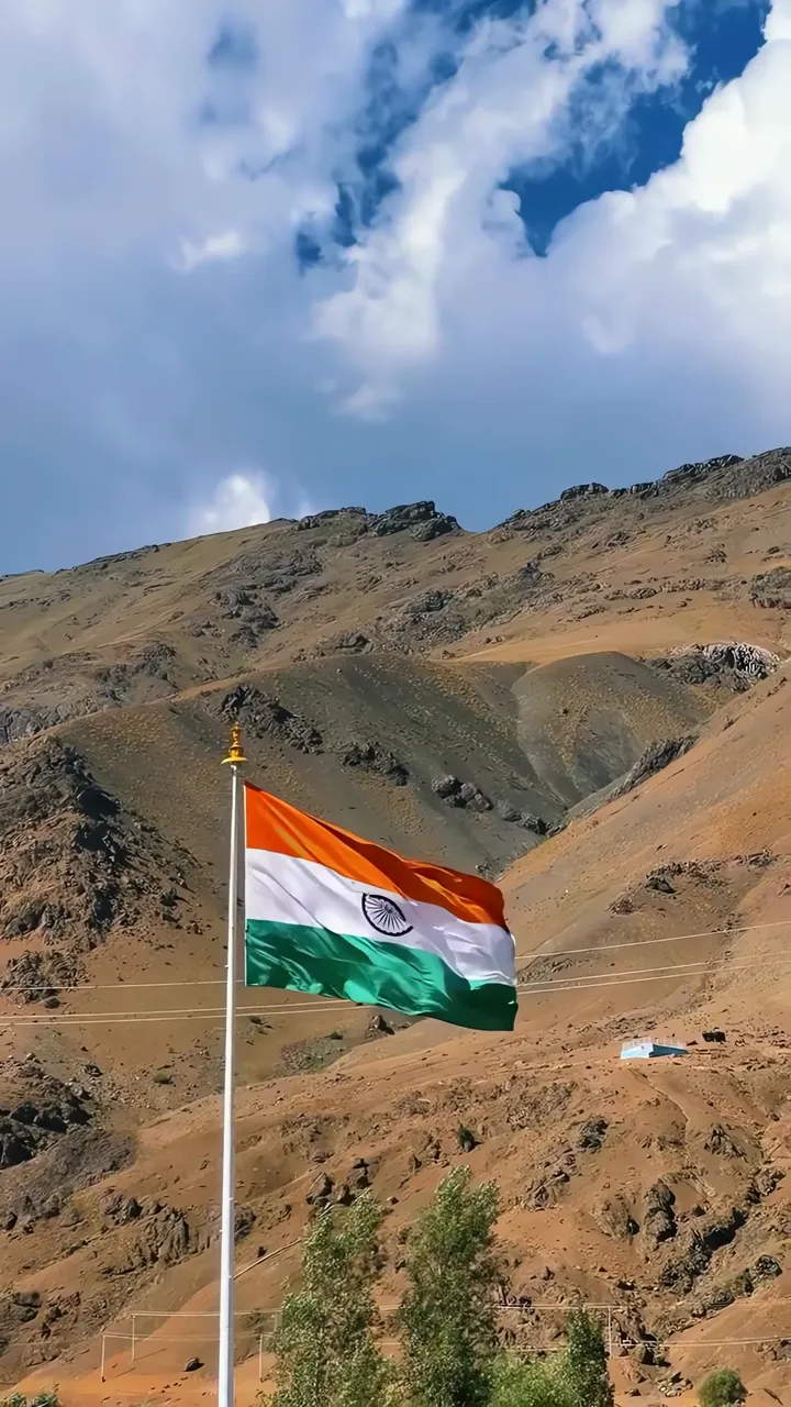 India Flag Waving In Mountainous Landscape With Blue Sky