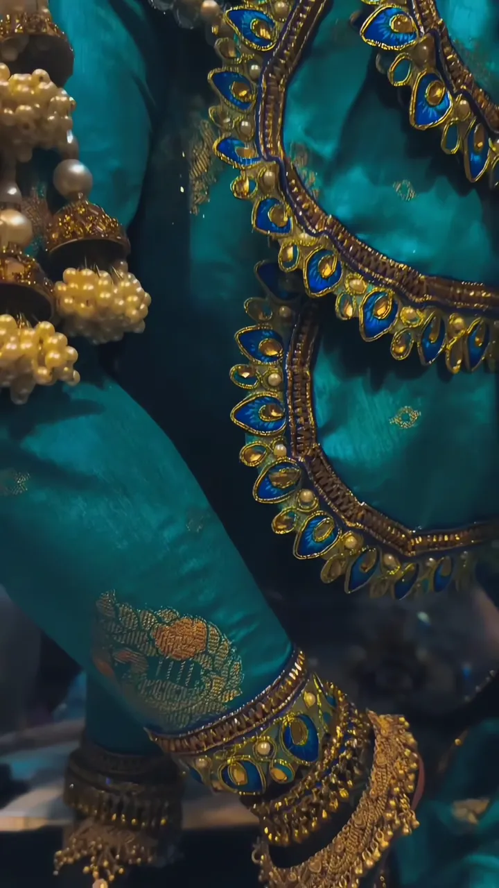 Krishna In Teal Silk With Peacock Feather Embroidery And Gold Jewelry