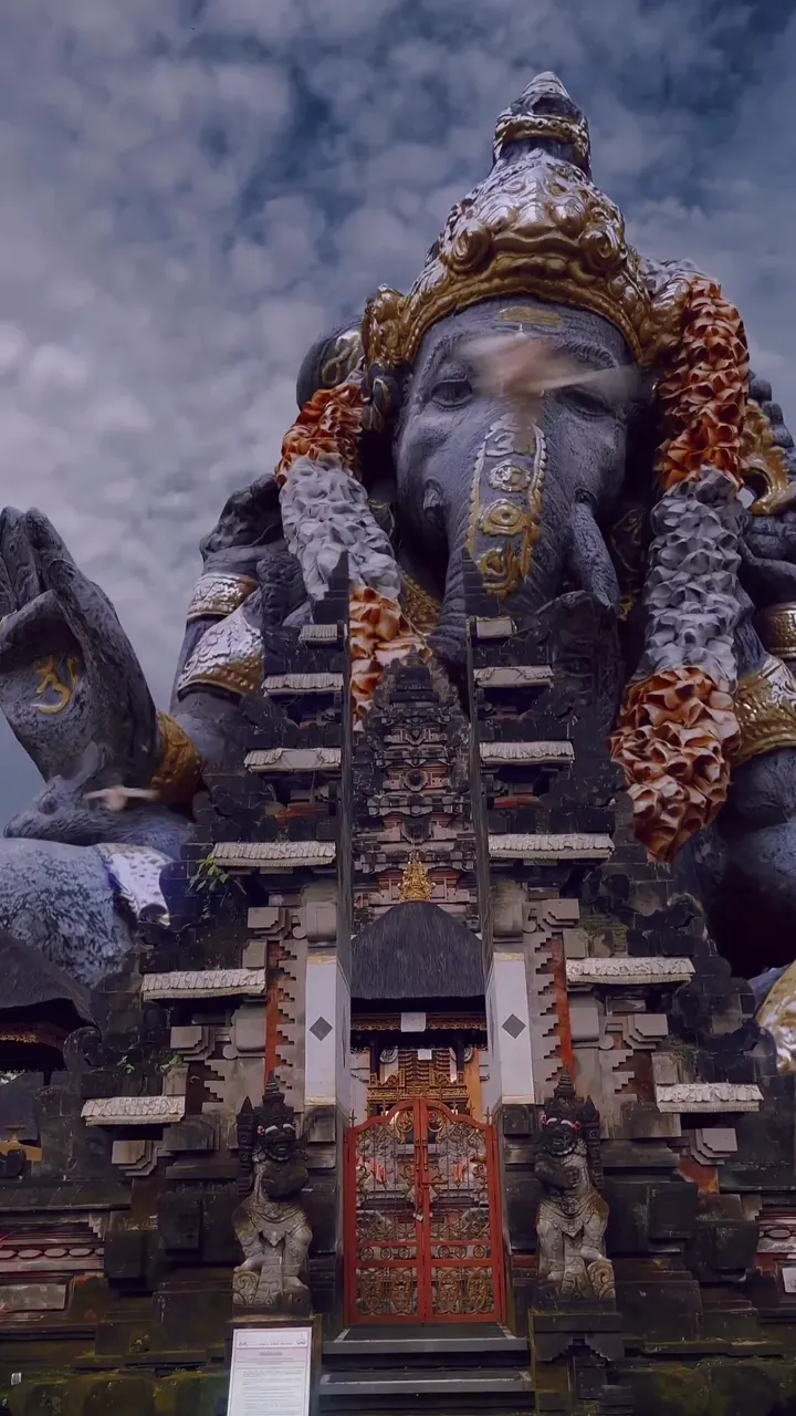 Ganesha Statue At Bali Temple With Ornate Gate