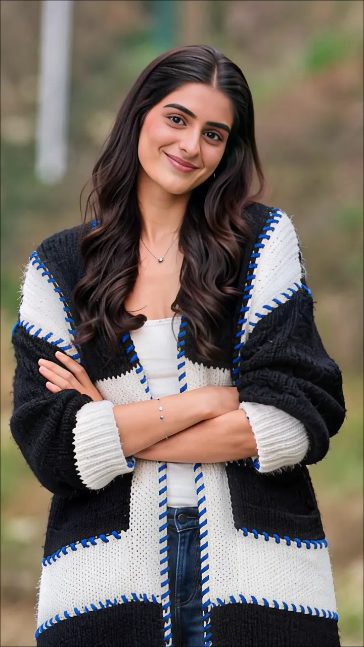 Smiling Woman In Black And White Knit Cardigan With Blue Stitch